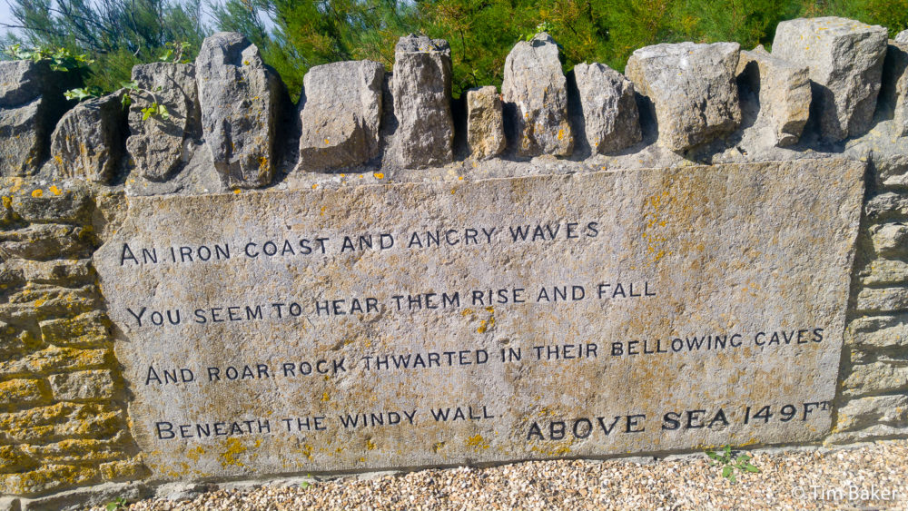 Durlston Castle - a sign saying "An Angry Coast And Angry Waves, You Seem To Hear Them Rise And Fall, And Roar Rock Thwarted In Their Bellowing Caves, Beneath The WIndy Wall. Above Sea 149Ft" quote from The Palace of Art by Alfred Lord Tennyson Swanage Jurassic Coast